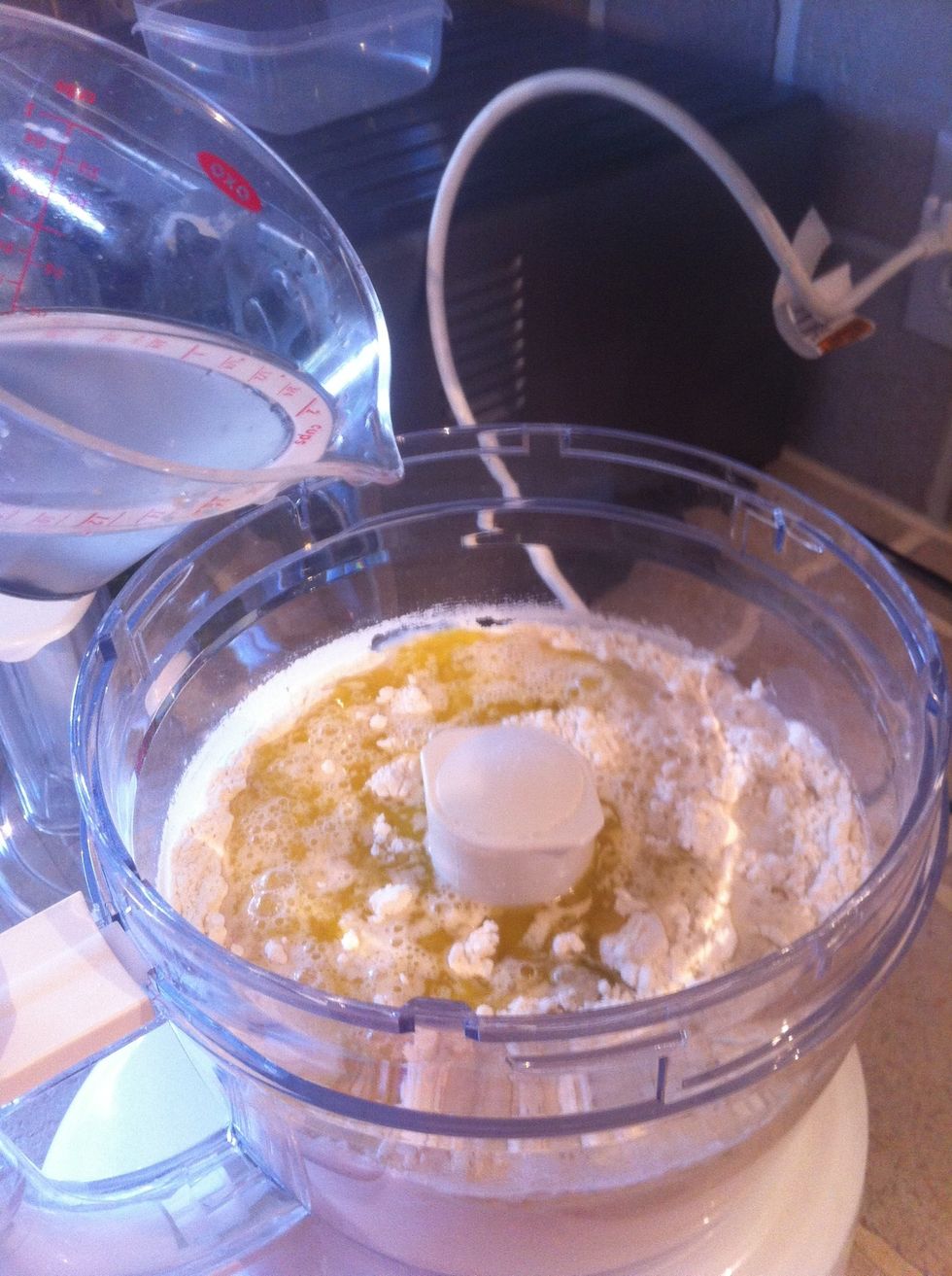Add 3 tablespoons of extra virgin olive oil. Then add the yeast mixture and about half the remaining water.