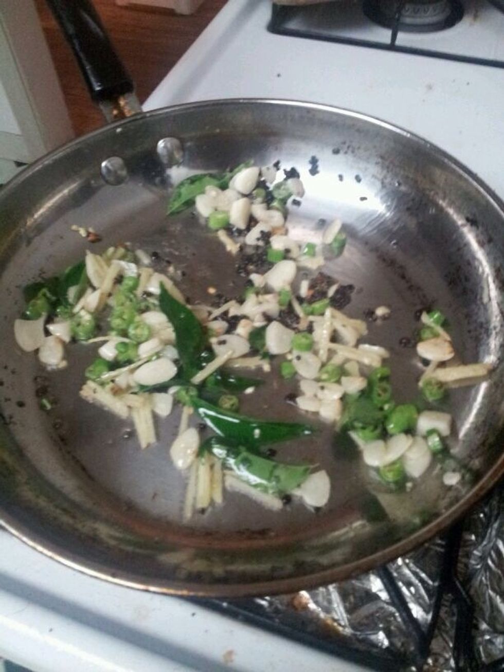 Add 3 tbsp oil and sputter mustard seeds and fenugreek seeds. Add ginger, garlic, and curry leaves