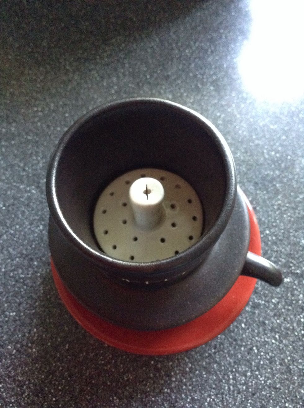 Add 3 teaspoonful of coffee into the dripper. Press it lightly (using the coffee presser) to ensure evenness of coffee on base of the dripper.