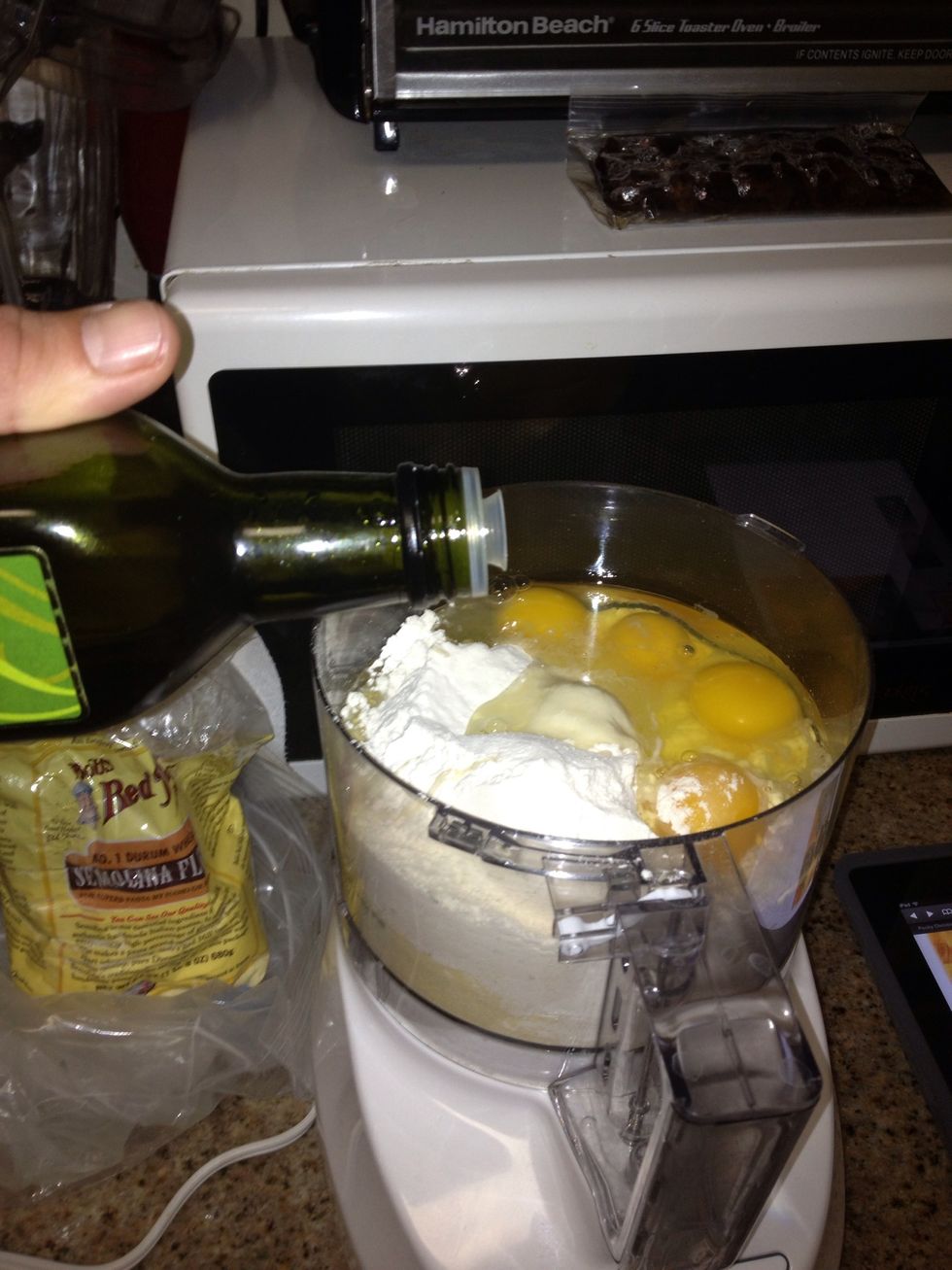 Add 4 room temp eggs and 1 egg yolk  (optionally add: 1/4 tsp salt and a drizzle of olive oil). You really need a 12 cup proccesor for this amount of dough.