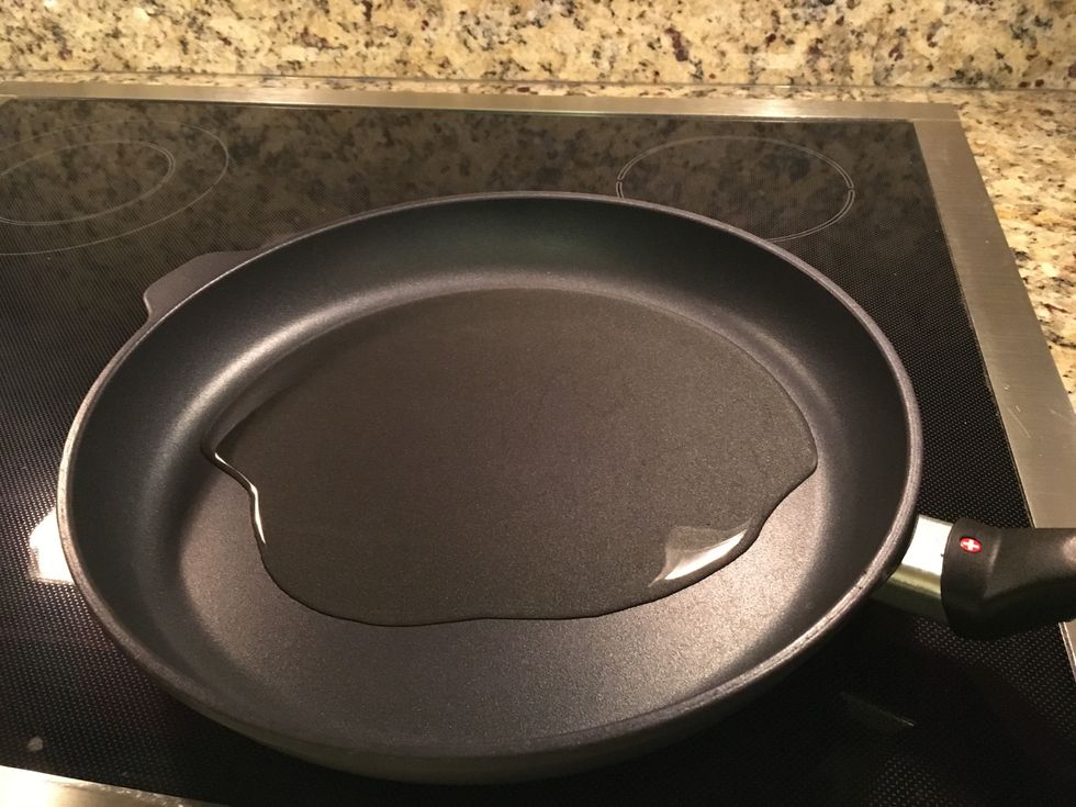 Add 4 tablespoons of olive oil to a large skillet over medium heat.