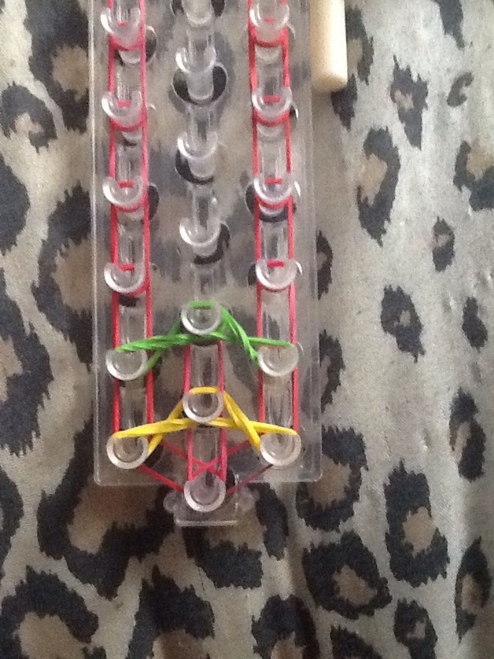 Add a band from that peg to the next, and repeat with the next color.