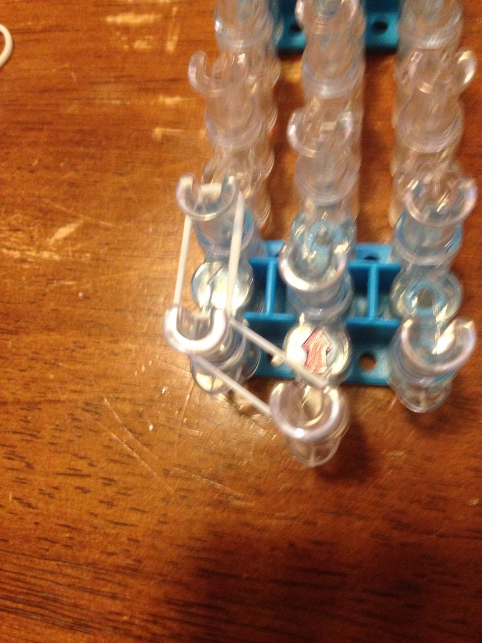 Add a band from the first left pin to the second left.