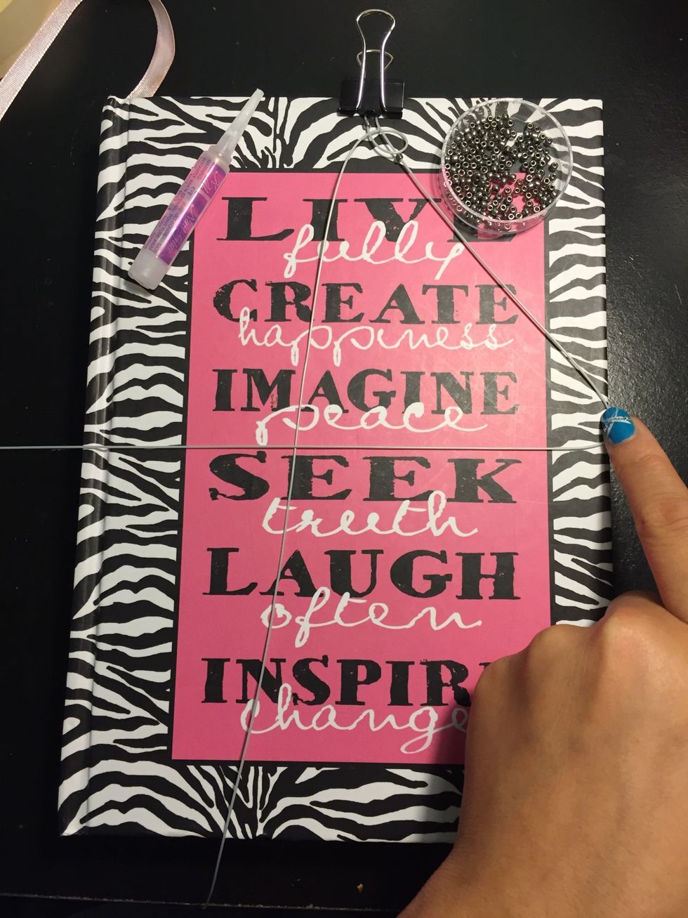 Add a bead and fold into a backward 4 with the right string