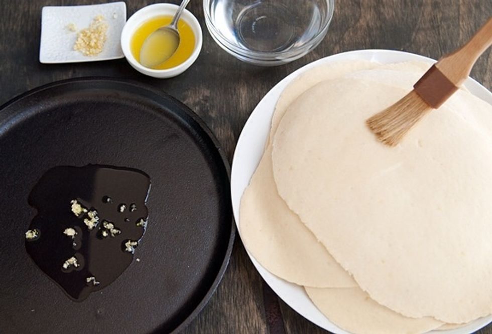 Add a bit of butter and garlic to the skillet, make sure not to burn the butter but just melt it. Then place naan on skillet, allow to cook for a couple of seconds.