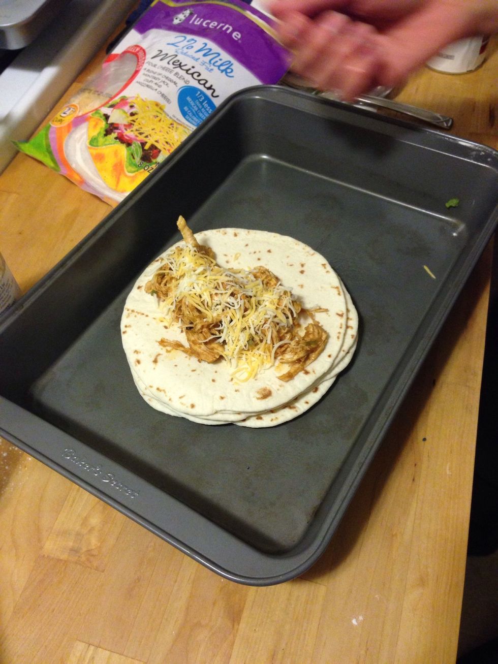 Add a bit of the Mexican blend shredded cheese to the top. It was around 1/2 tsp per enchilada.