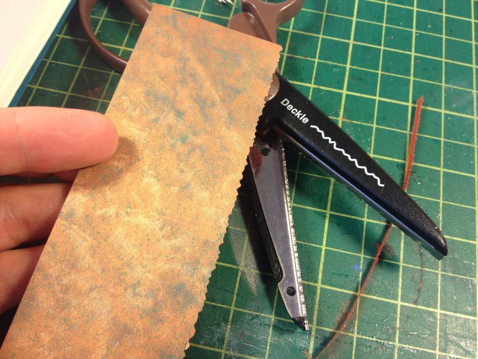 Add a cool spine detail. Cut a strip of paper 1"-2" wide and make it as long as your book is tall. Use scrapbook scissors for a fancy edge along one side.