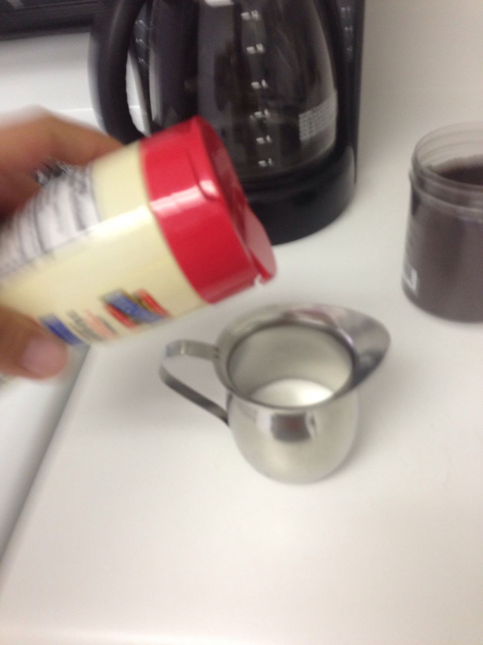 Add a couple table spoons of sugar into the small metal coffee cup.