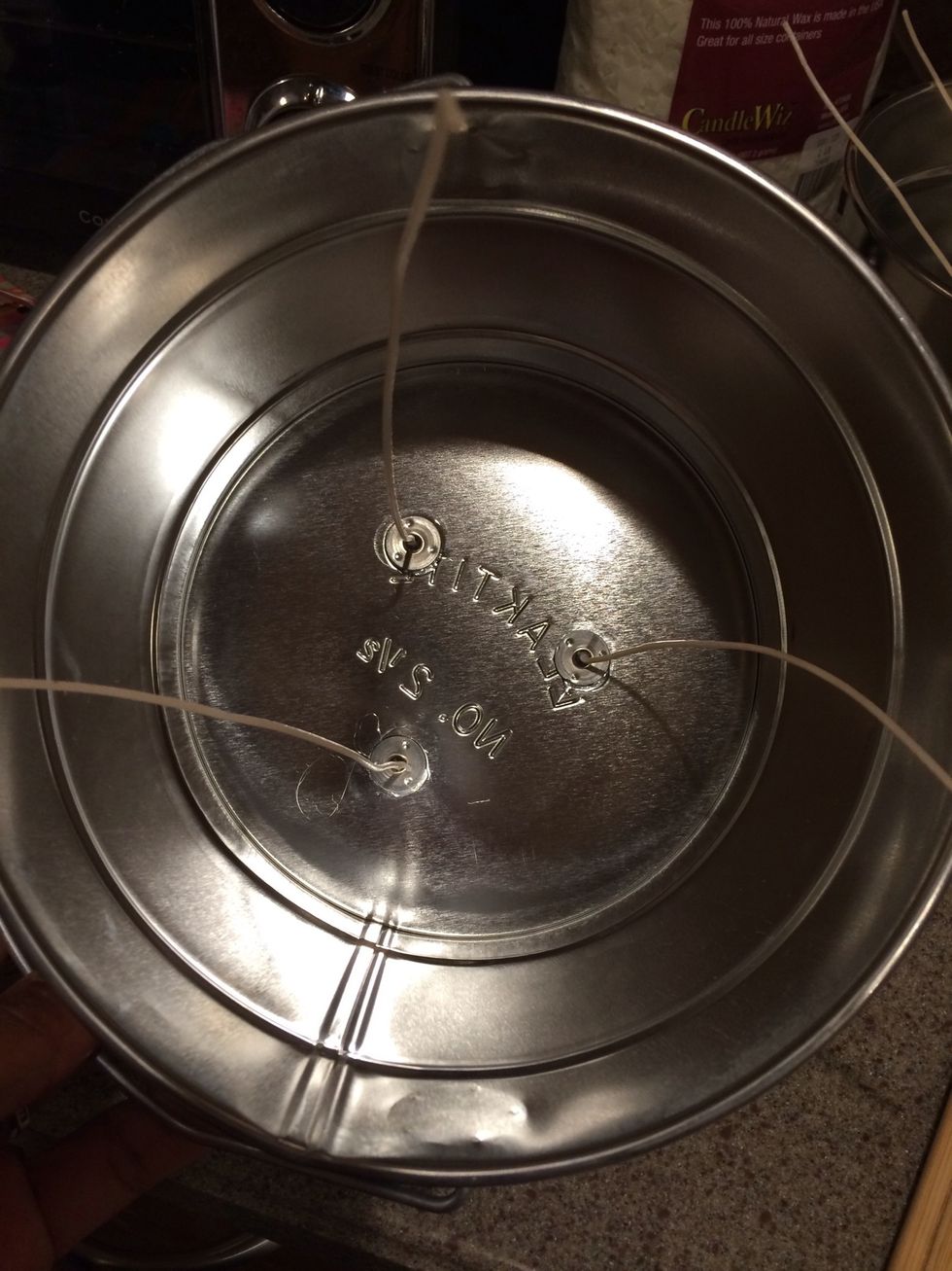 Add a dab of hot glue to the bottom of the wick and affixed to the bottom of the candle. Space out all three wicks and allow to dry.