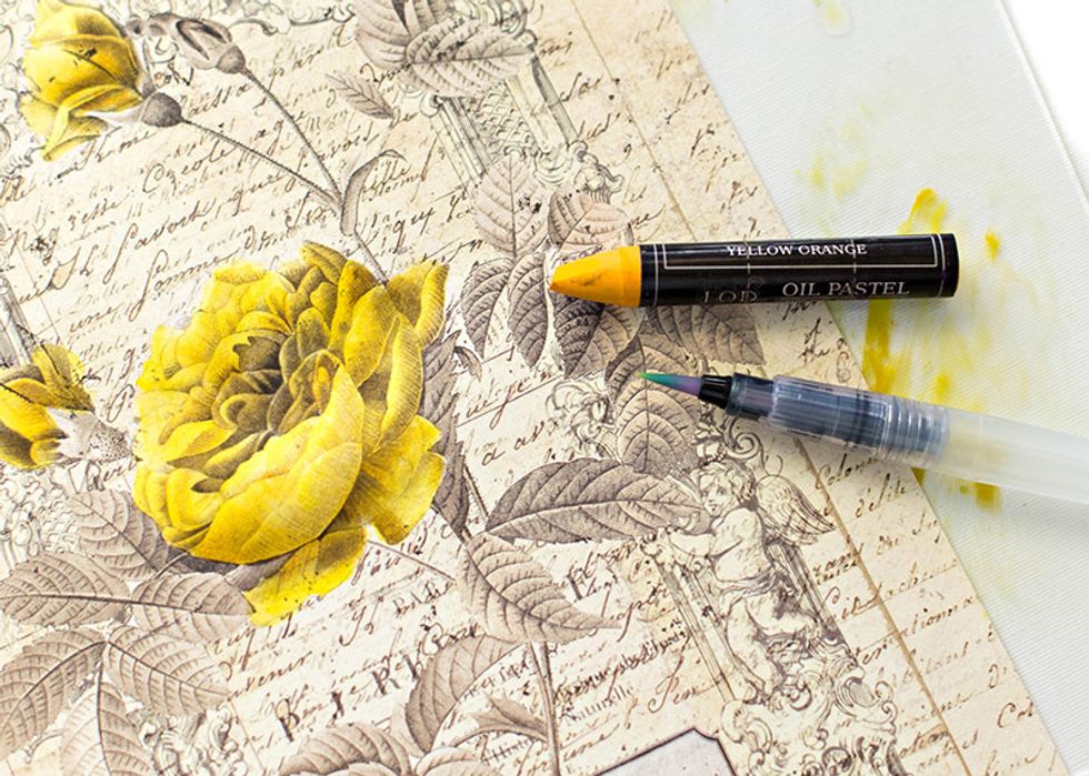 Add a darker color on to the craft mat. (I used yellow-orange.) Then begin coloring the shadow areas of the flower with the darker color and the waterbrush.