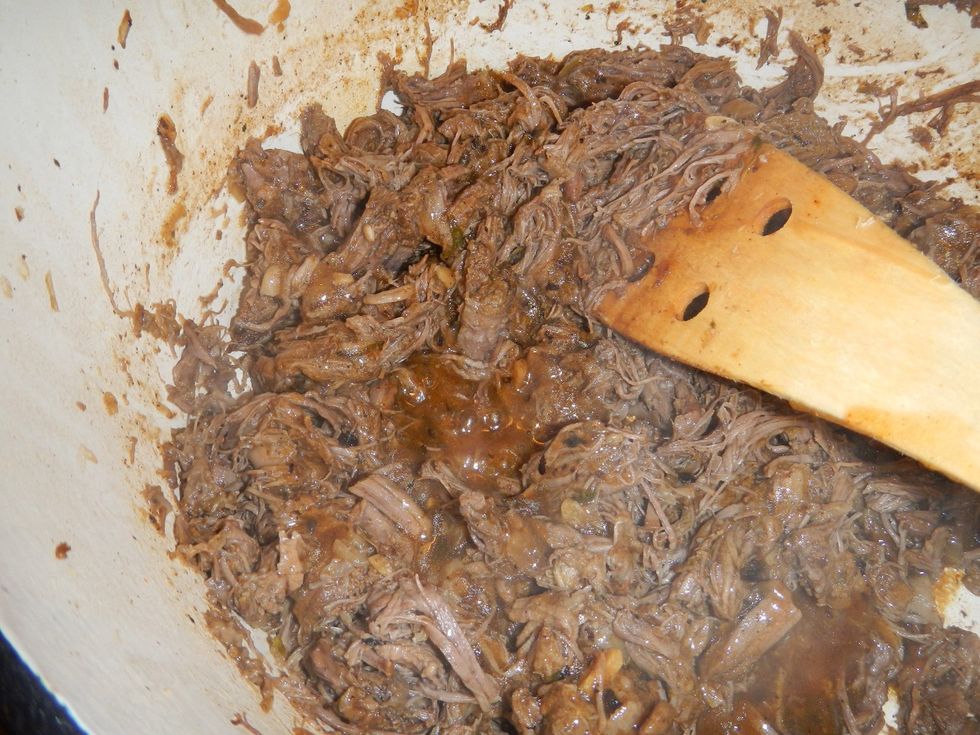 Add a few spoonfuls of the thickened au jus back into the shredded meat.
