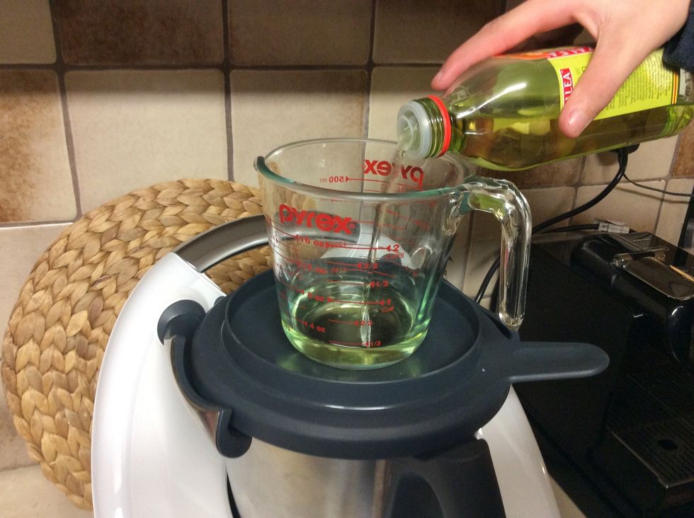 Add a jug on top of the mixing bowl lid and tip 80g of grapeseed oil into the jug. Put jug to the side for now