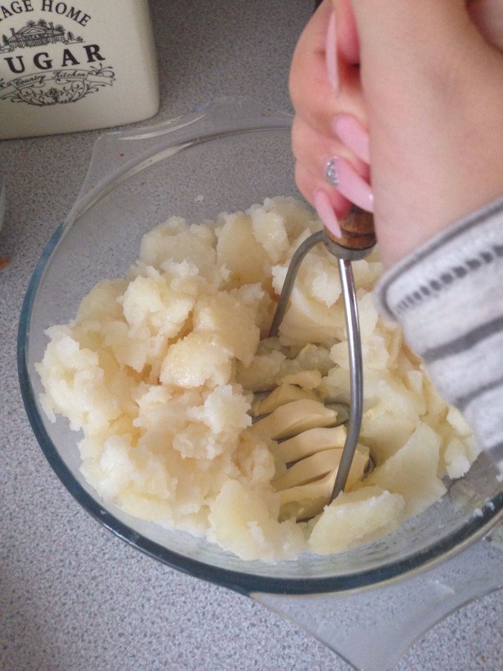 Add a knob of butter and a splash of milk and get mashing! Then add in the grated cheese and continue mashing!