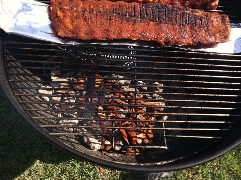 Add a large handful of soaked wood chips on top of the coals.  Add another handful every 15 - 45 minutes, depending on the desired level of smoke flavor.