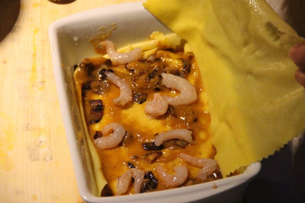 Add a layer of fresh pasta which has been boiled for 20 seconds in hot boiling salted water and made cool down in cold water for 30 seconds. Add your shrimps