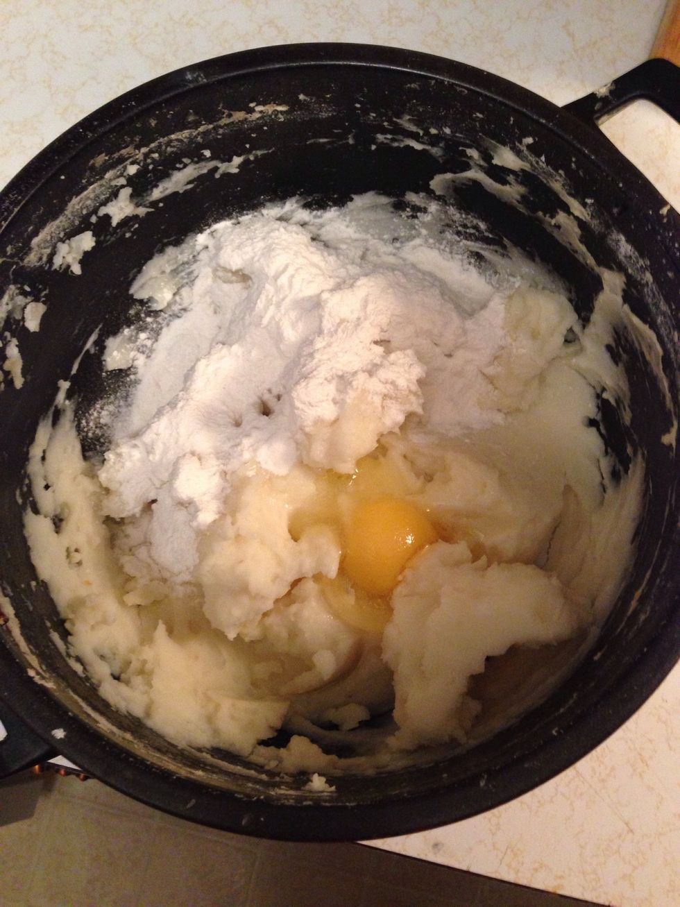 Add a little bit more salt to your mashies. For my amount I used two eggs and a little bit of milk. Add some flour and start mixing it in.