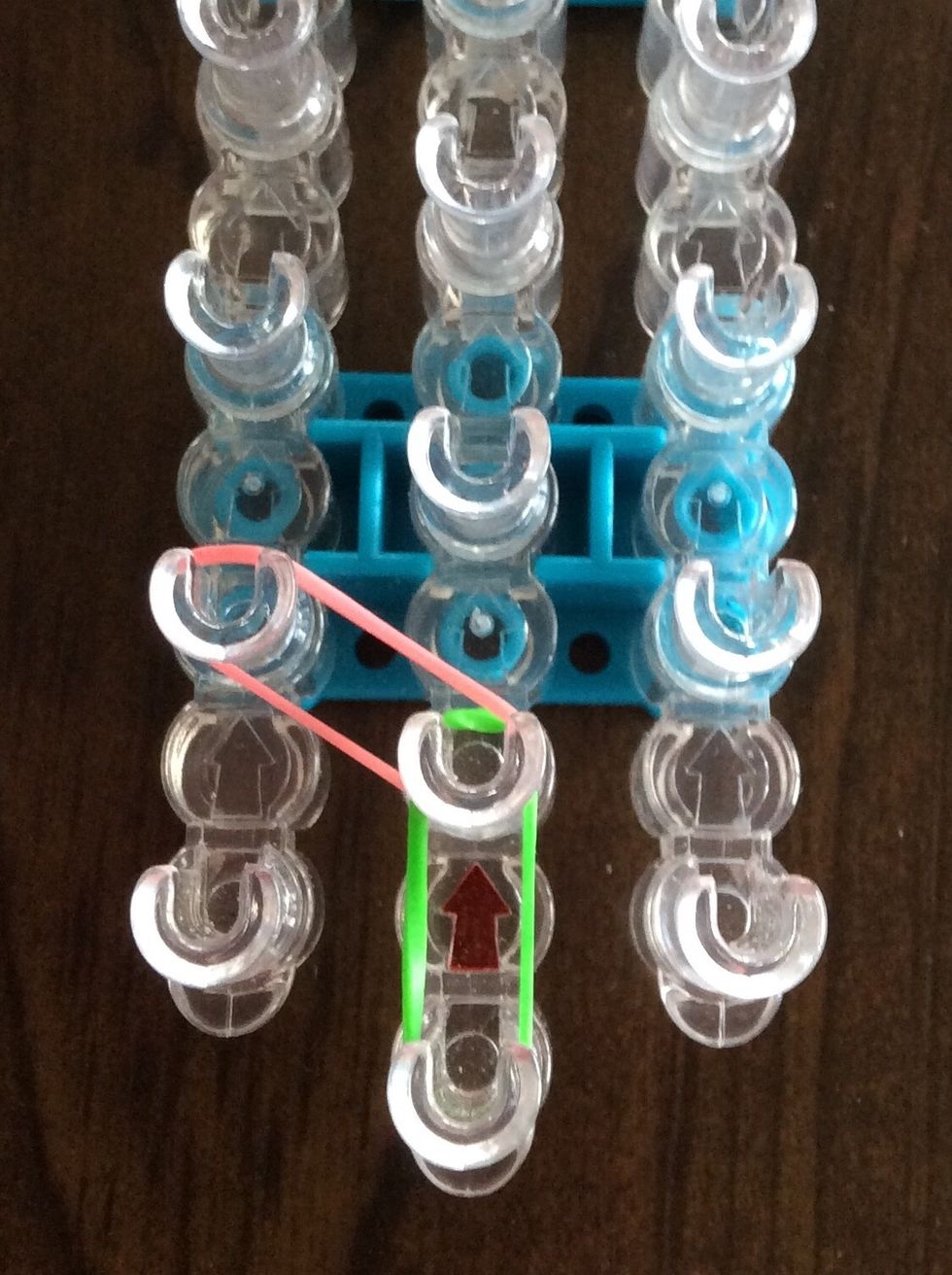 Add a pink band from the second middle peg to the second left peg.