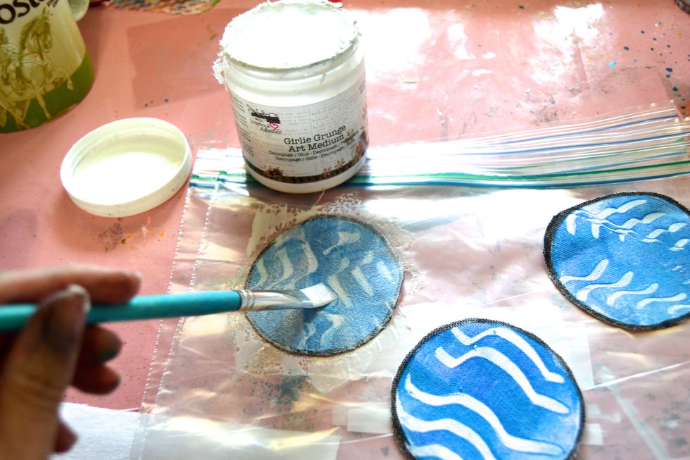 Add a protective surface (like this plastic bag.) Cover each circle well with a medium, like this Grungy Girl Art Medium from 3L. This will strengthen your fabric and keep it from fraying.