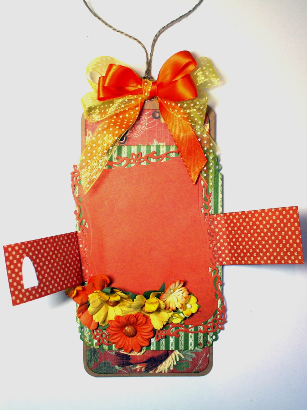 Add a ribbon at the top and some flowers near the bottom that will serve to keep the seed packet from sliding through the bands and will embellish your tag.