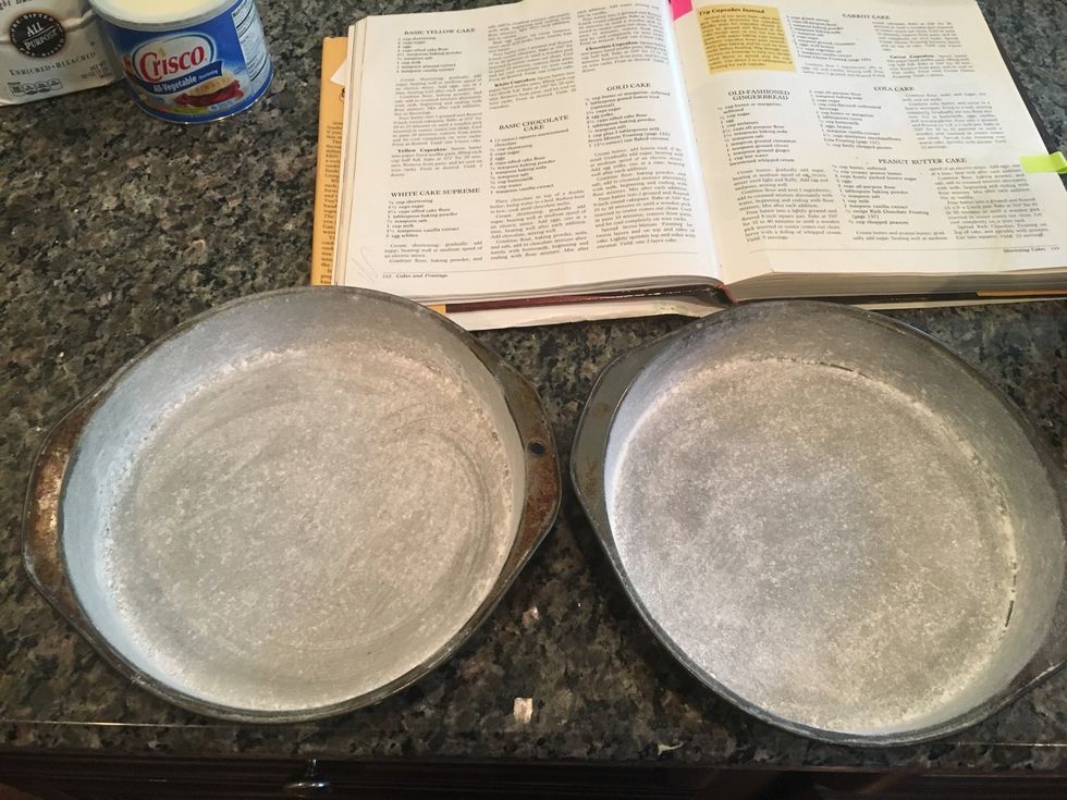 Add a small amount of flour into the greased pan and smooth the flour so that there are no clumps. This step helps prevent the cakes from sticking to the pans.
