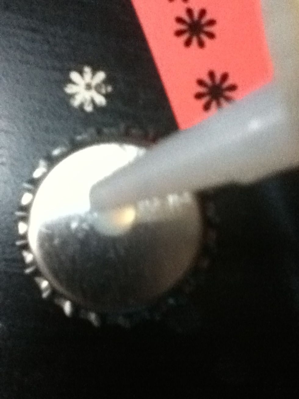 Add a small dot of glue to the bottom of your bottle cap.