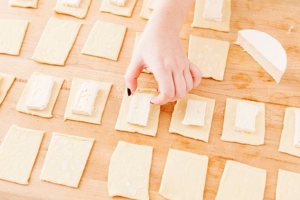 Add a small rectangle slice of brie to 1/2 of your rectangles. You should have 24 small rectangles to make 12 baked brie bites.