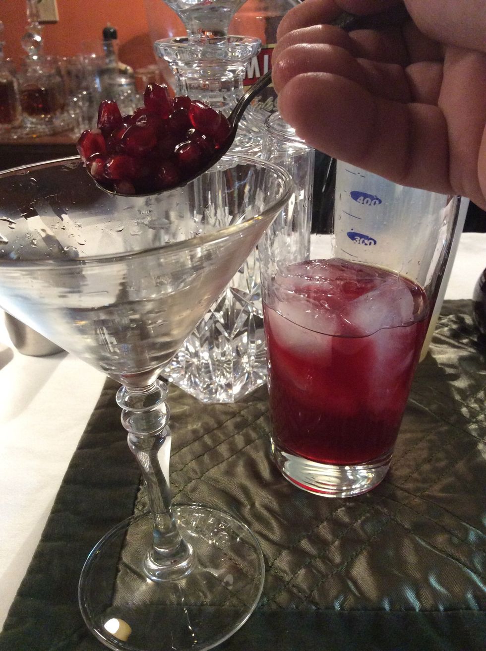 Add  a spoonful of pomegranate seeds to martini glass.