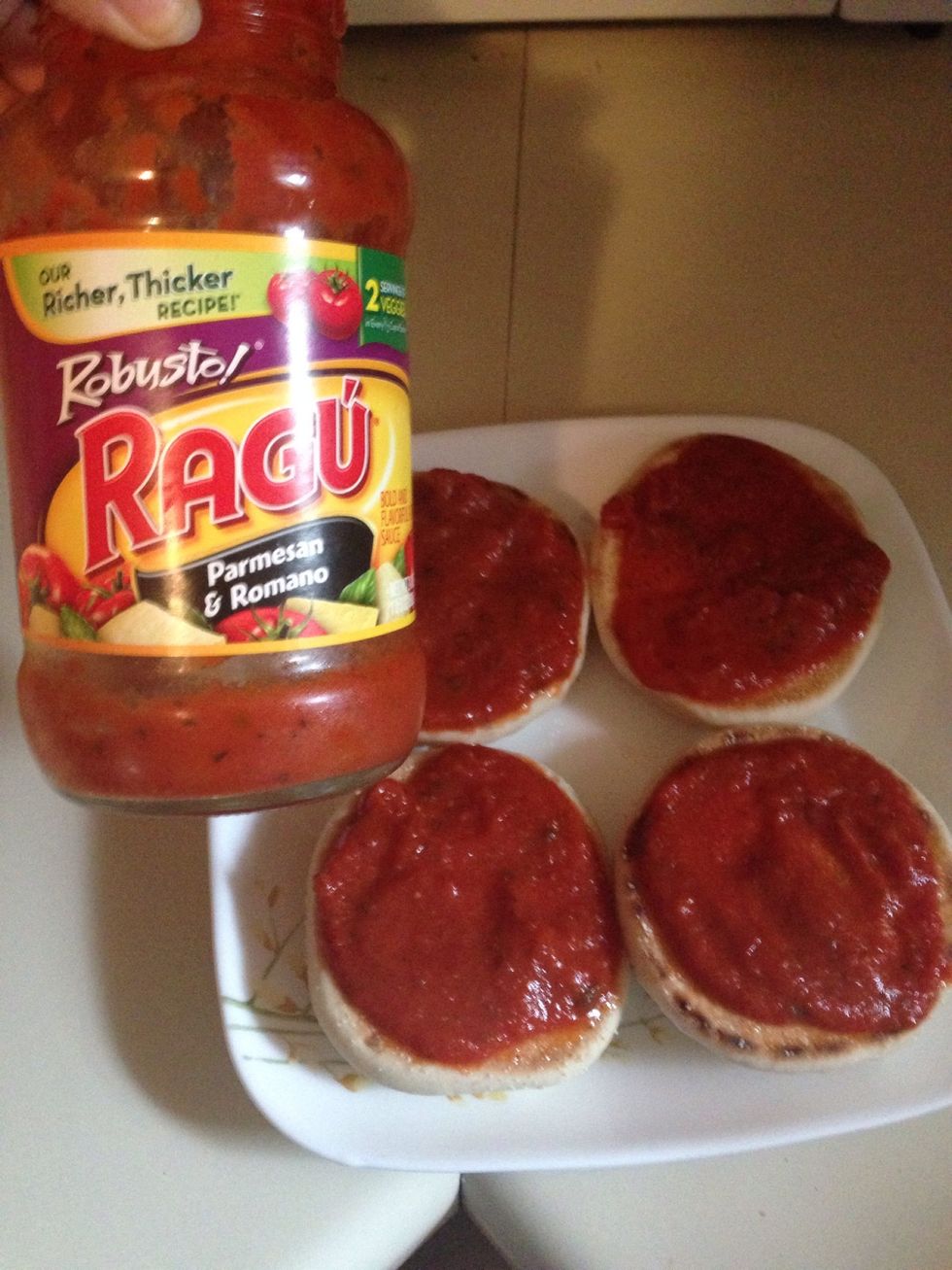 Add a spoonful of spaghetti sauce to each muffin.