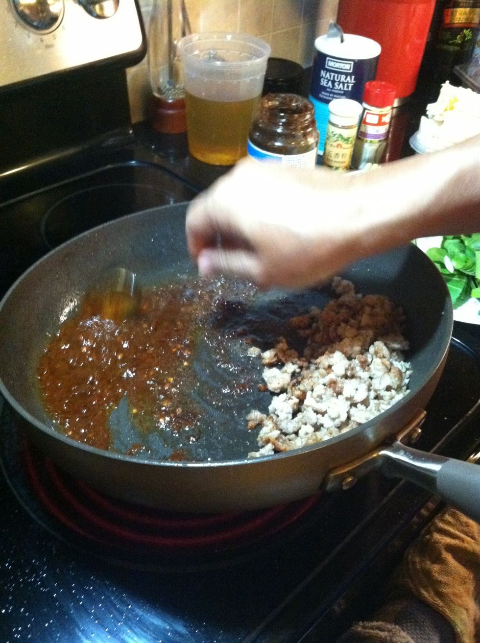 Add a tbsp of veg oil, soy paste, garlic, ginger, soy sauce(opt) and chili sauce on the opposite side of the pan. Stir to combine, simmer for 10 sec, or until the oil has turned red from the chili.
