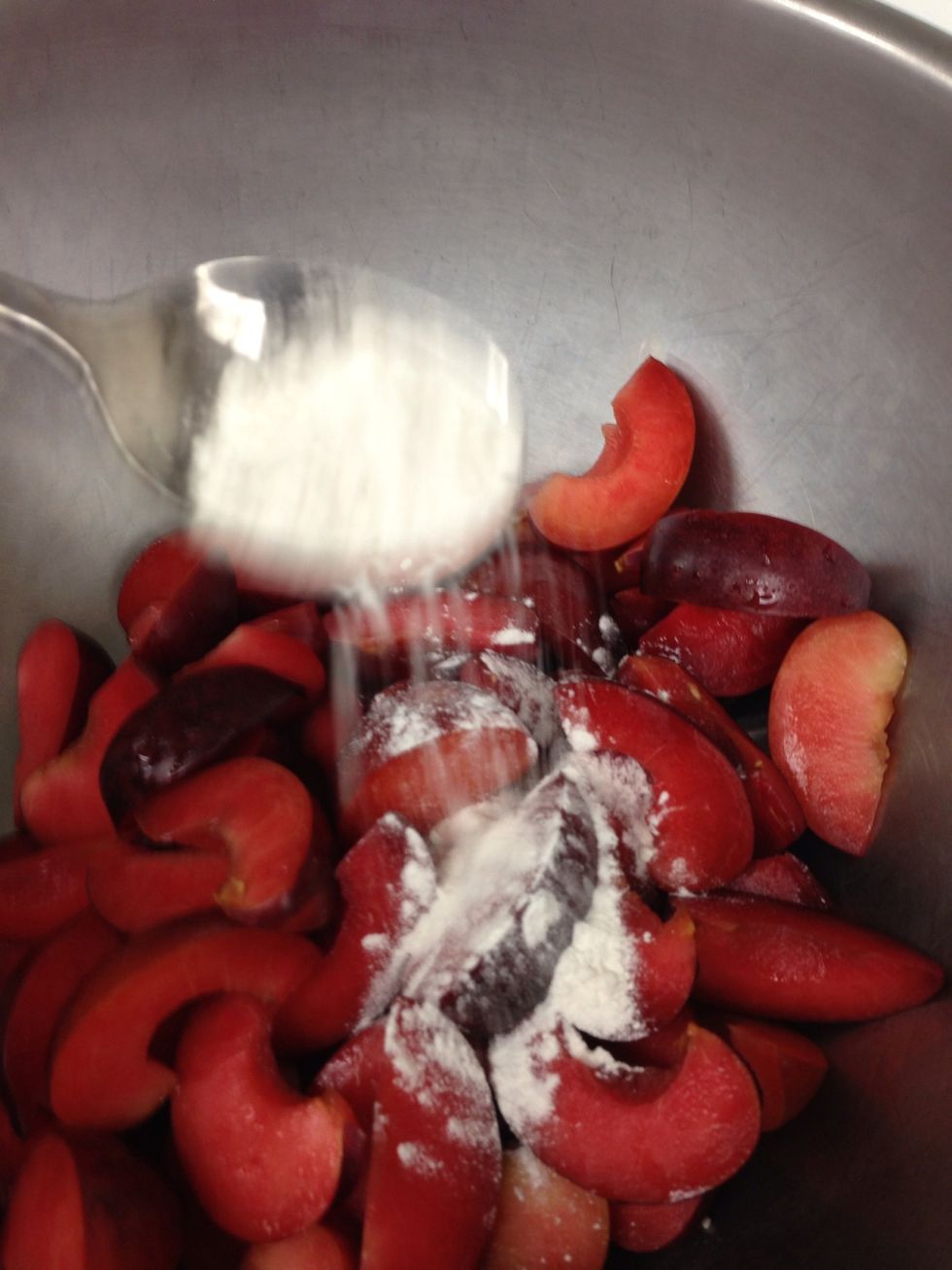 Add a teaspoon of the flour to the plums.