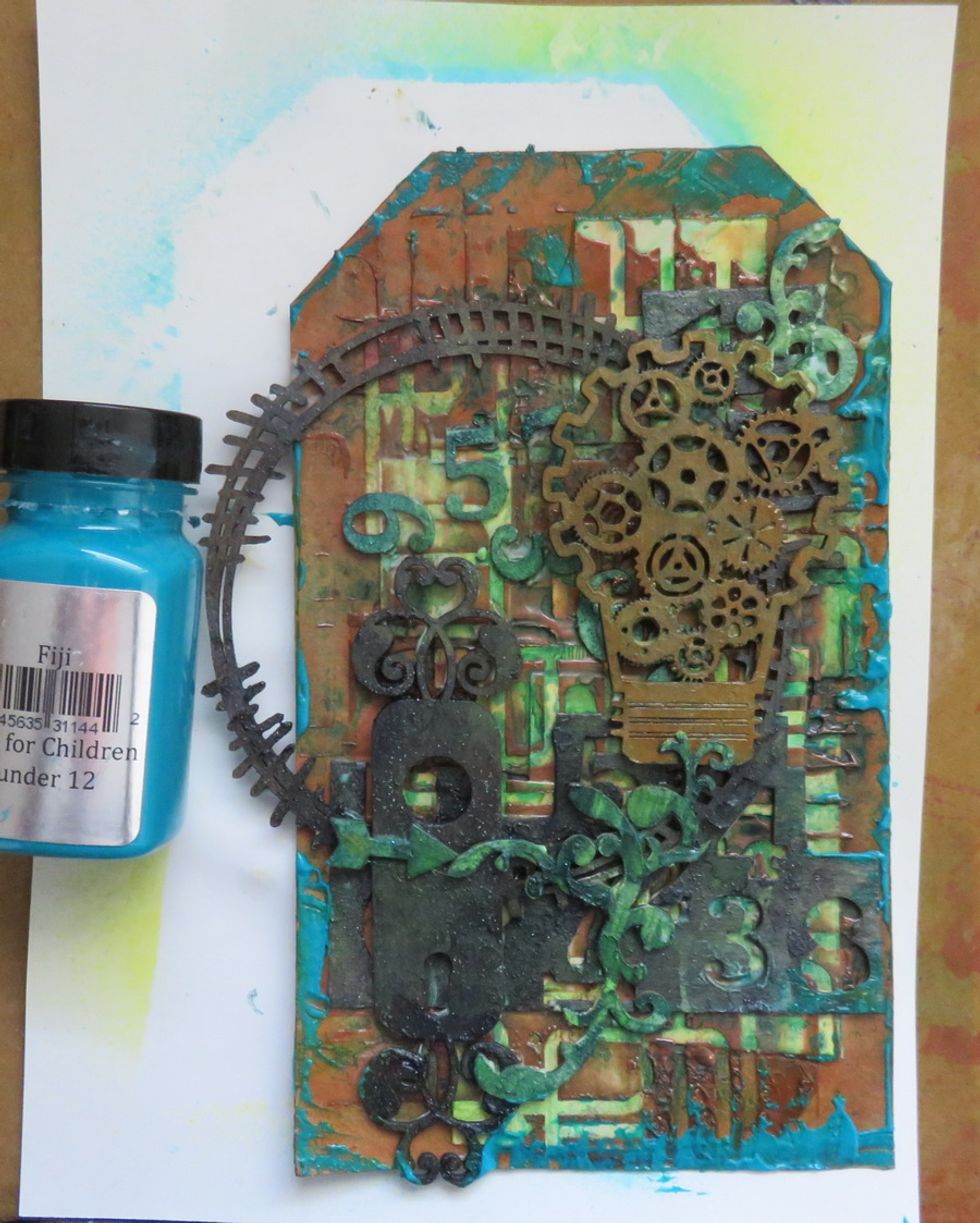 Add a touch of Fiji paint around the tag and over some of the chipboards.