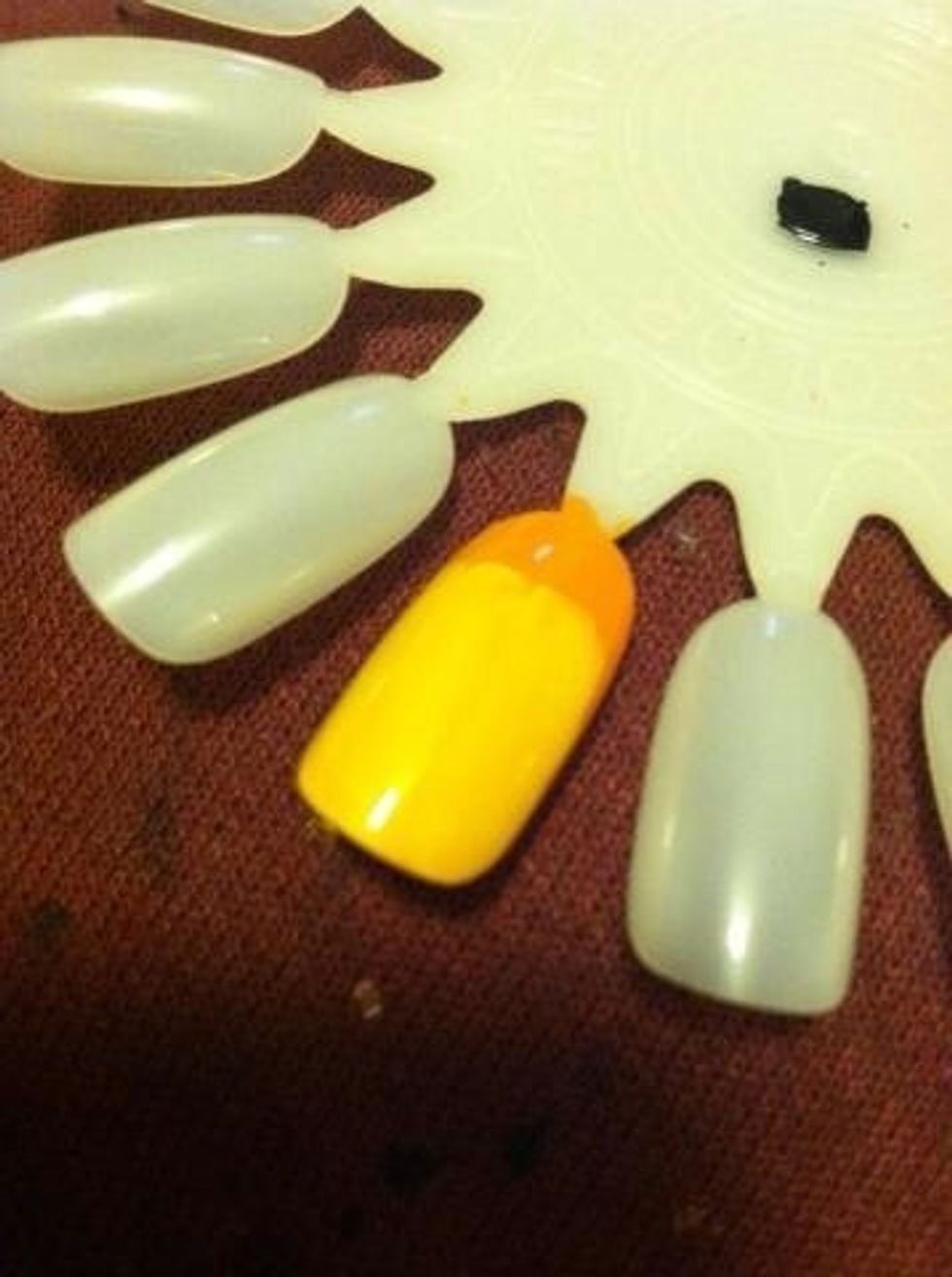 Add a yellow but don't color the whole nail. Leave a little orange.