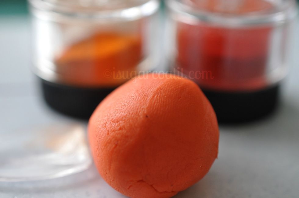 Add about 1/2 tsp. of exotic orange and poppy petal dust to colour the remaining gum paste. Knead until evenly distributed.