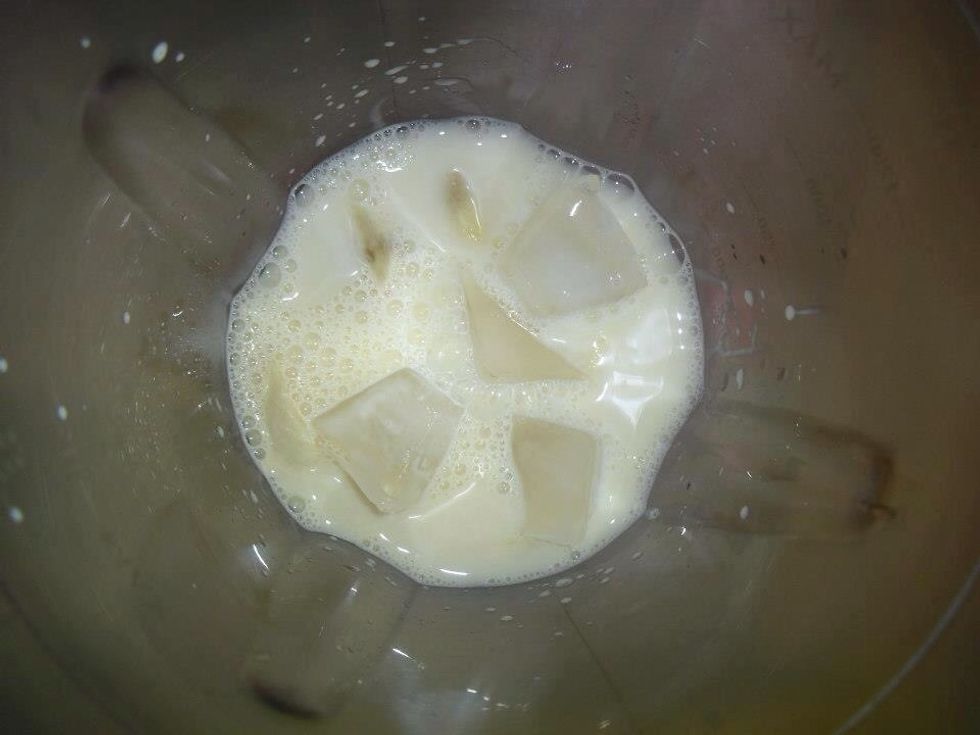 Add about half a cup of milk to the blender along with crushed ice