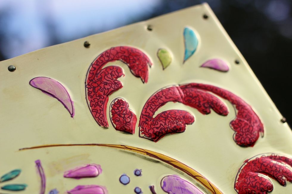 add accent designs to flourishes around skull as well to skull outline using Sharpie...