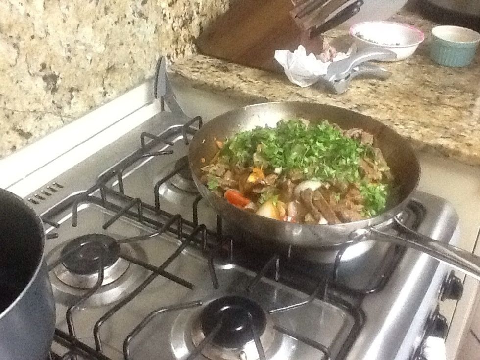 Add all ingredients (meat, tomatoes, onions, pepper) to fry pan for additional heating and add some chopped cilantro.