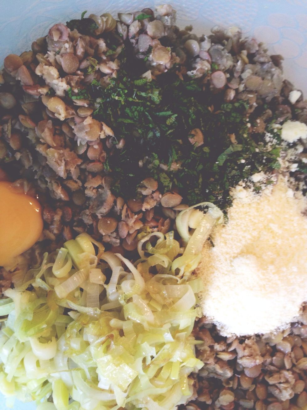 Add all of the chopped mint, 1 egg, the remaining cup of Parmesan, the saut\u00e9ed leeks and garlic and half a teaspoon of salt to the lentils and mix thoroughly.