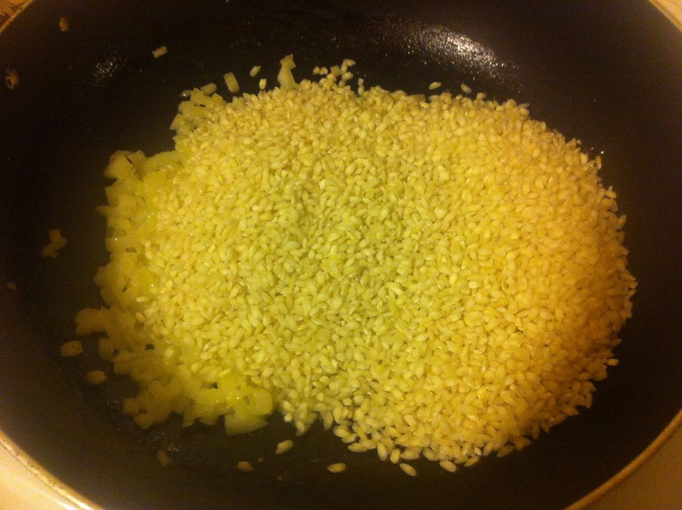 Add all of the rice, and cook the rice until they become clear and only a small amount of white is visible in the center of each grain.