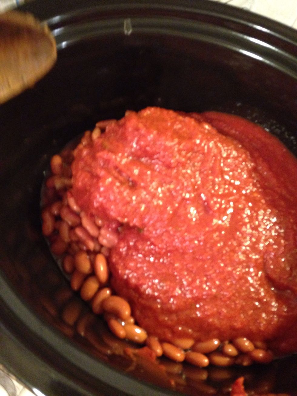 Add all the beans, crushed tomatoes and half the can of tomato paste.