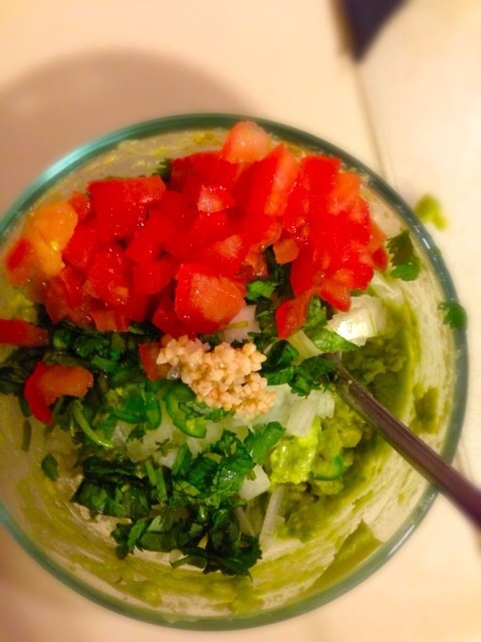 Add all the chopped vegetables to the mashed avocado. Also add a little bit of minced garlic