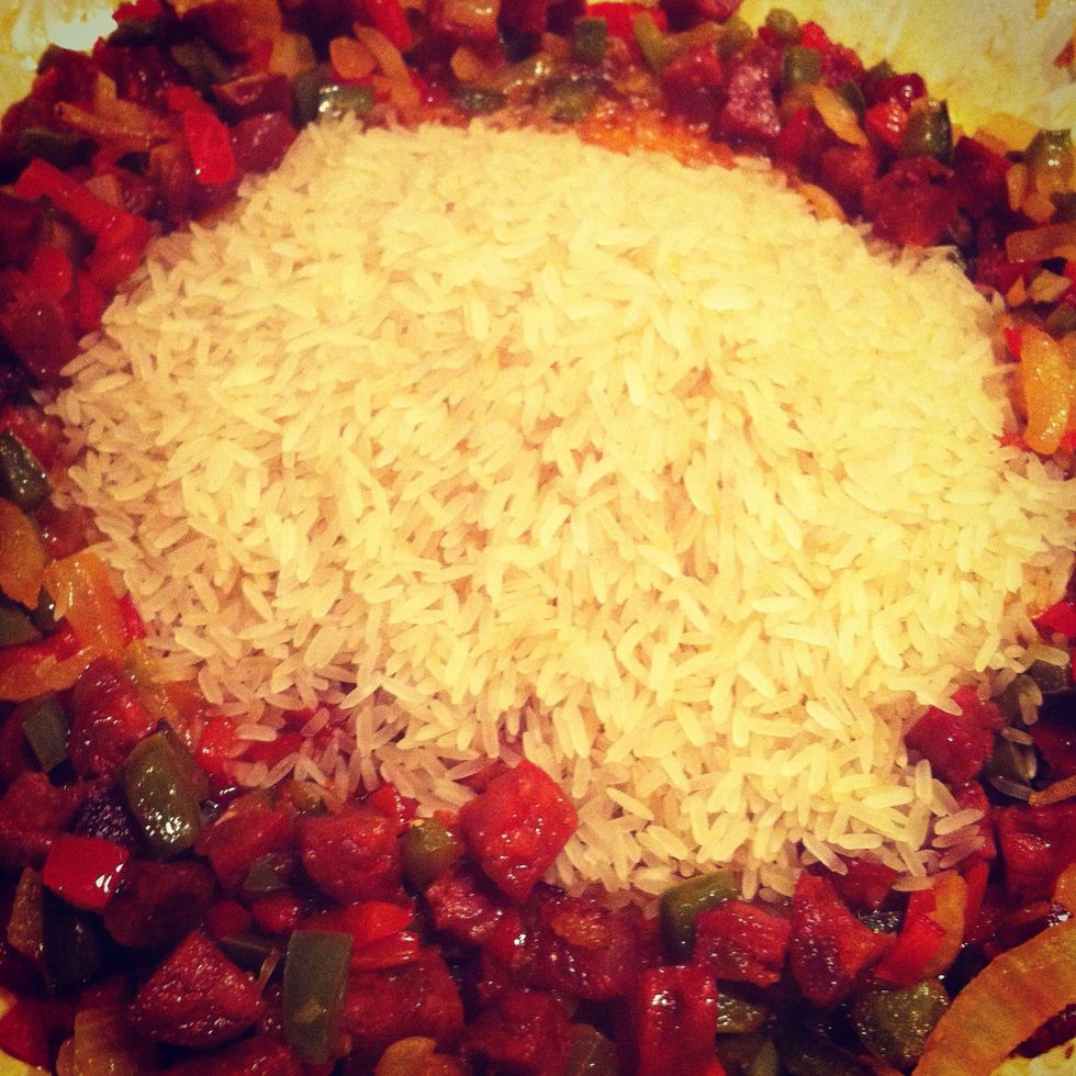 Add all the rice into the pan. Stir gently to coat  each grain in the delicious oils and juices. Cook for 3-5 minutes until the rice grains turn translucent.