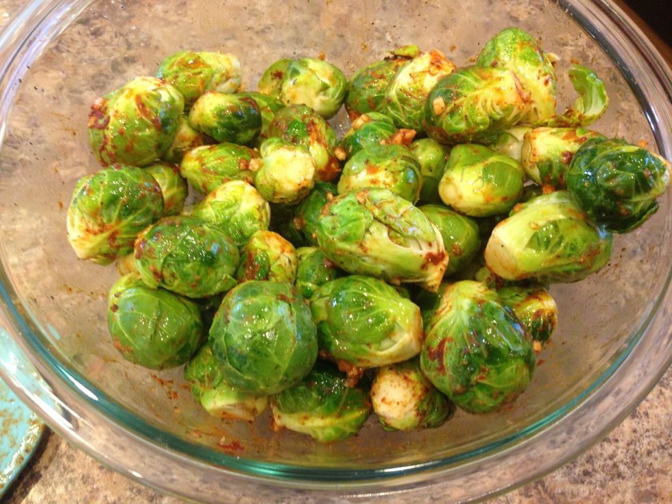Add all the spices to the Brussels sprouts and mix well. You want to make sure all the Brussels sprouts are seasoned well.