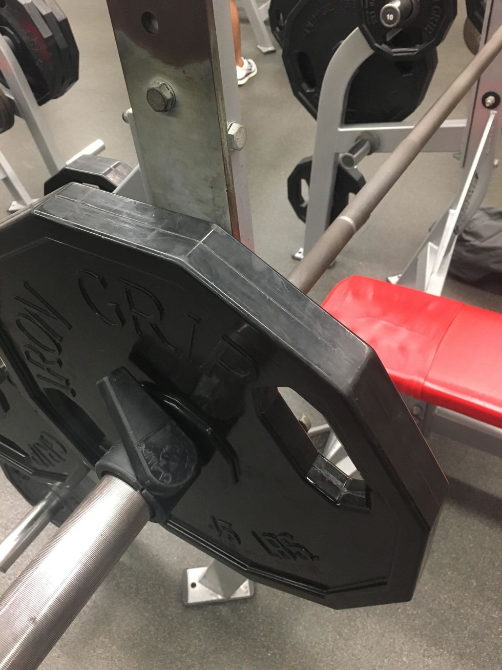 Add an equal amount of weight to each side of the bench making sure to secure the weights with safety clips