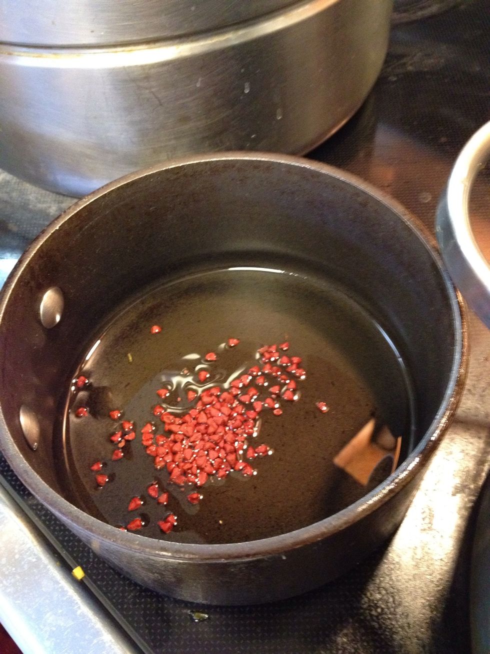 Add annatto seeds to a small pan of oil and heat for a couple of minutes. Annatto seeds help create the currys' deep orange color.