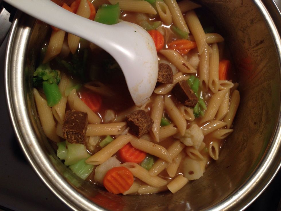 Add another cube into the pot. Stir until those pieces have also dissolved. The pasta water will thicken, and turn into a sauce. Make sure all of the pasta and veggies are covered in this sauce.