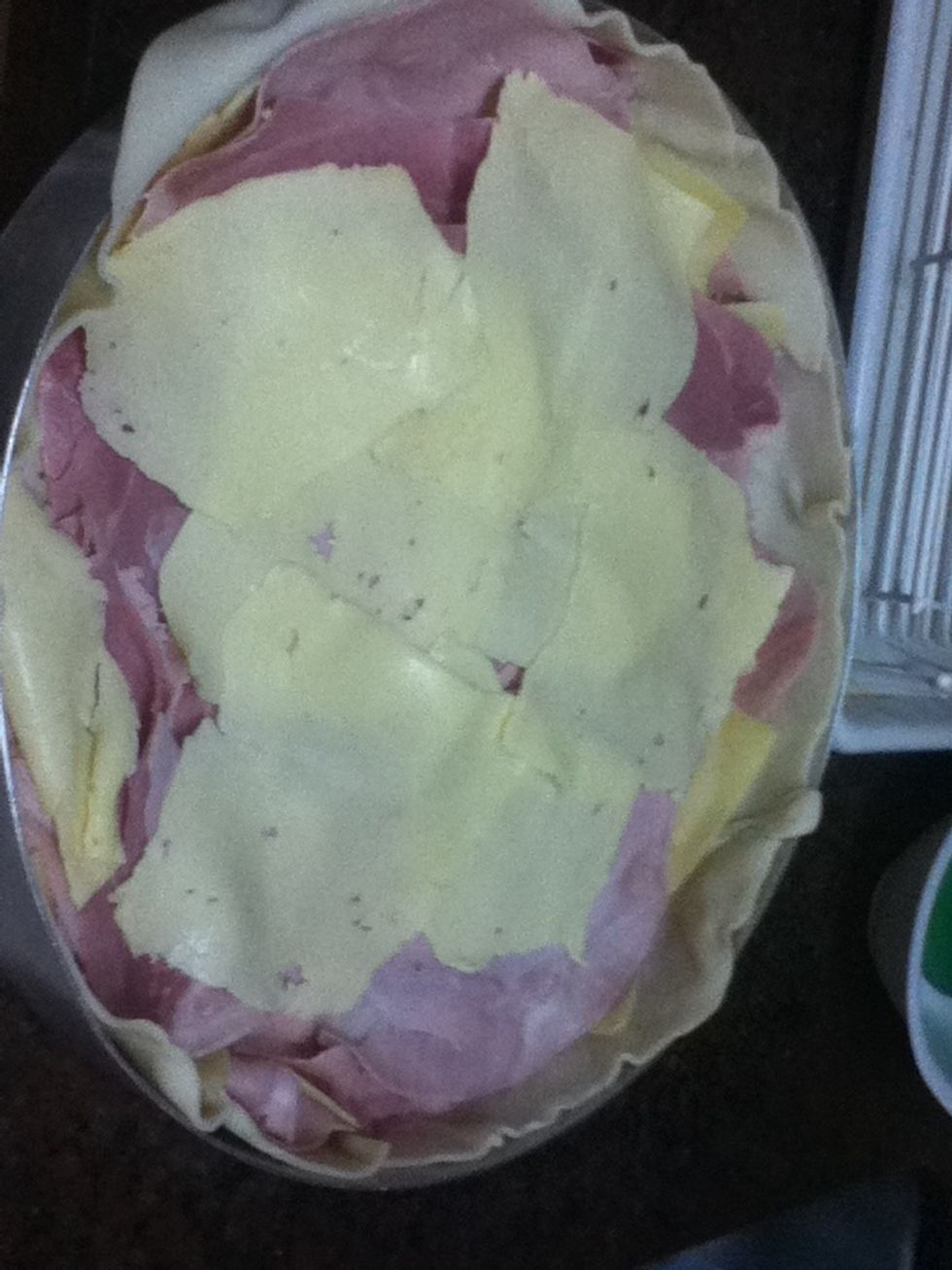 Add another layer of ham and here i put another type of cheese (called sandwich cheese) Here you can add anything you wish, some people add tomatoes, onions. But my family dont like it in the pie!