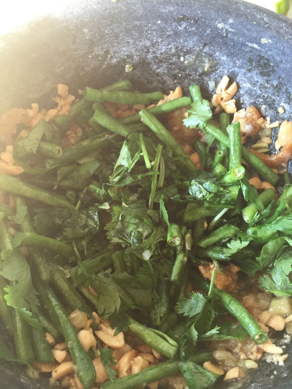 Add basil and cilantro and continue to bruise it. Both basil and cilantro is optional. I love to add basil in my salad. Love the taste and smell of it.