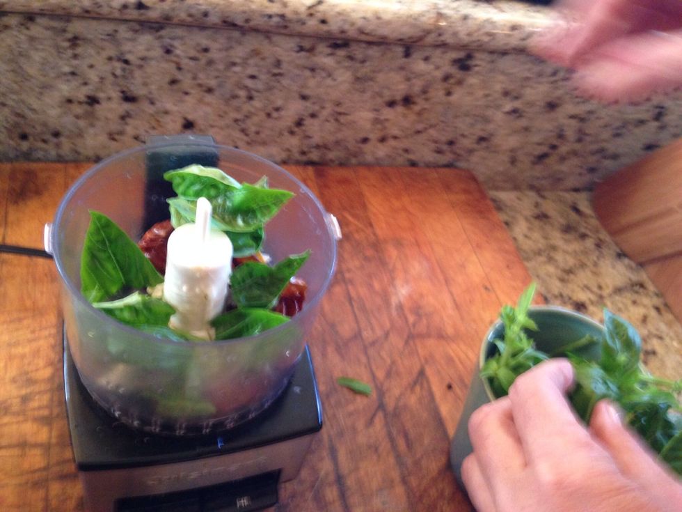 Add basil and sundried tomatoes to a food processor.