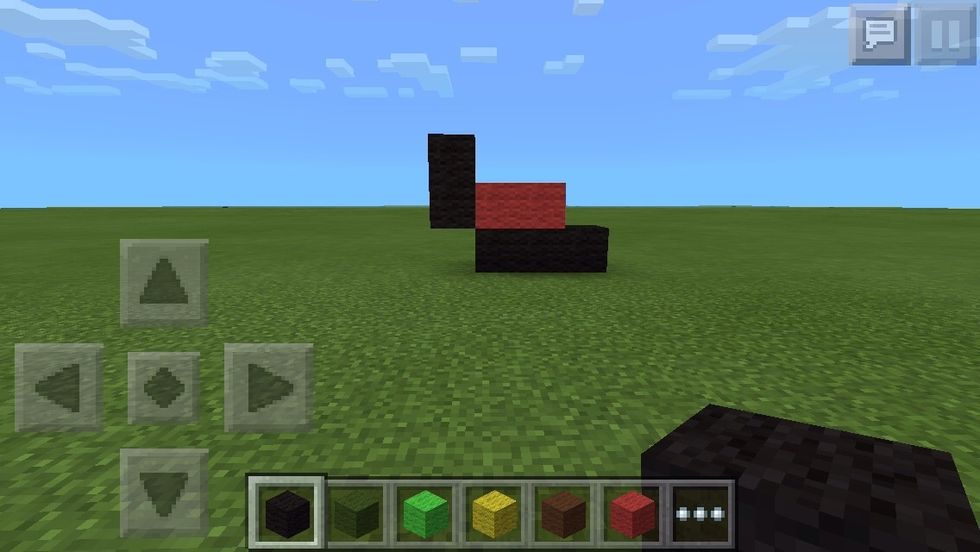 Add black wool beside the red on the left side, then go up one.