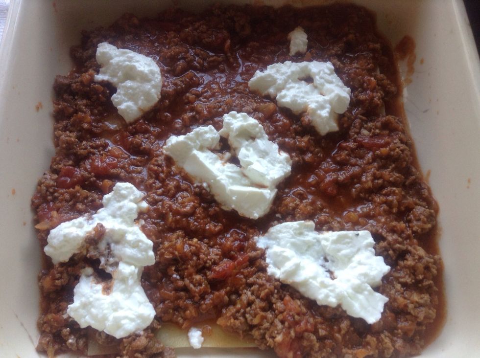 Add bolognaise sauce on top of the pasta, and the ricotta cheese on top